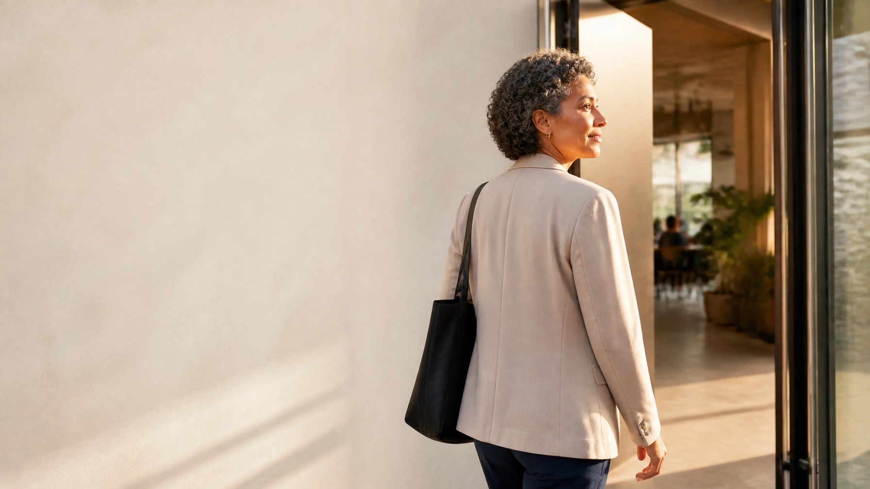 Woman standing near a bright doorway, symbolizing a hopeful step forward after emotional pain